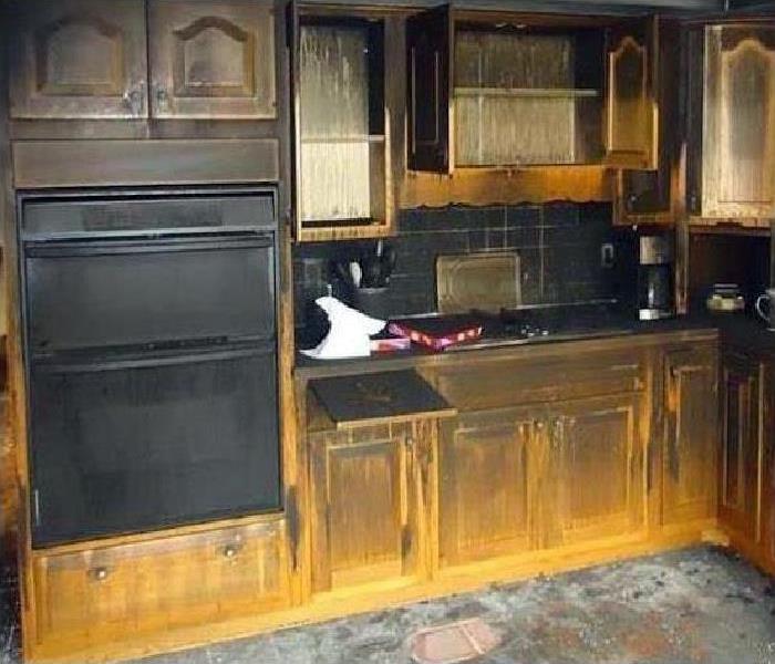 kitchen covered in soot after a fire with wood cabinets