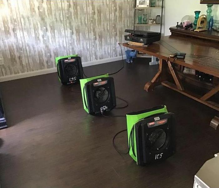 Room with hardwood flooring and SERVPRO drying equipment