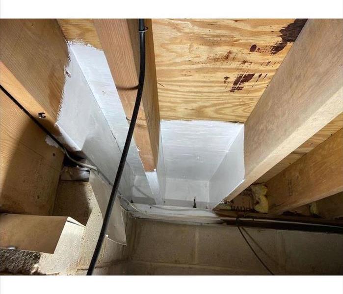 Crawl space with antimicrobial sealant on boards