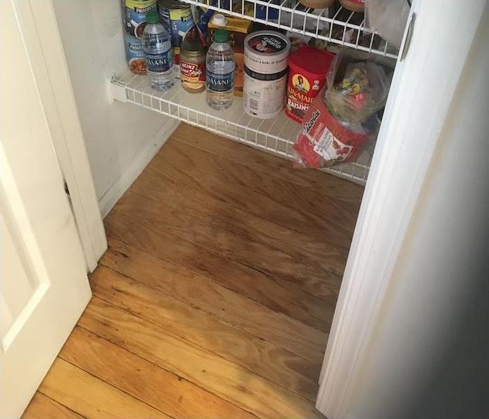 wet floorboards and trim in an opened pantry