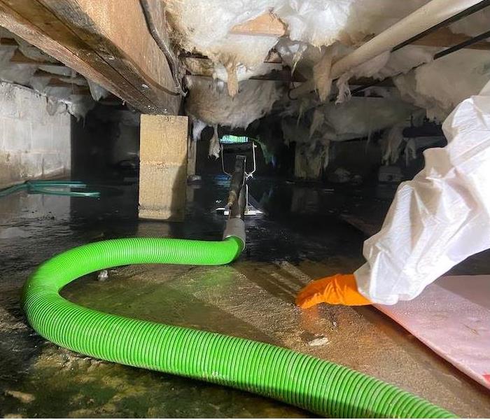 SERVPRO tech in crawl space with equipment