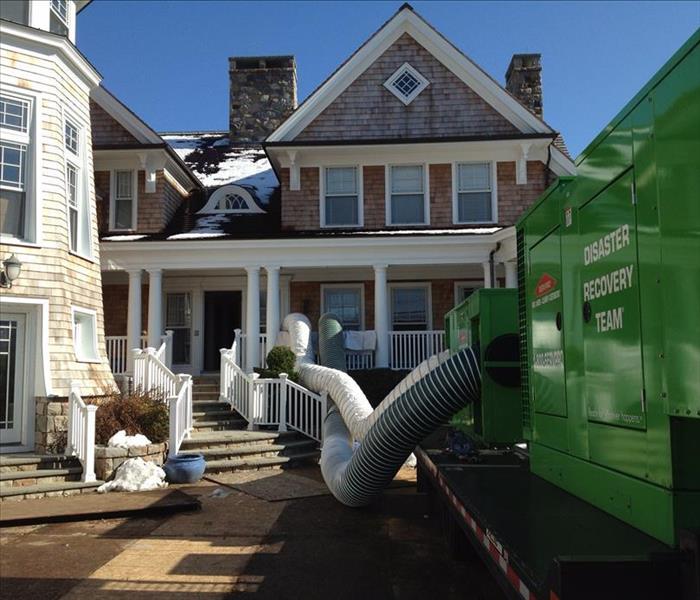 tan home with SERVPRO equipment on front driveway