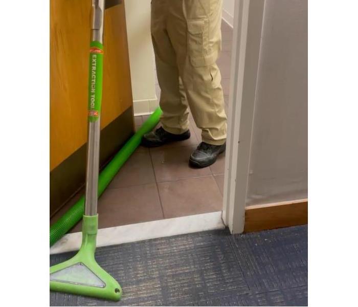 SERVPRO of Toms River technician using professional wet/dry vacuum to extract water from carpets